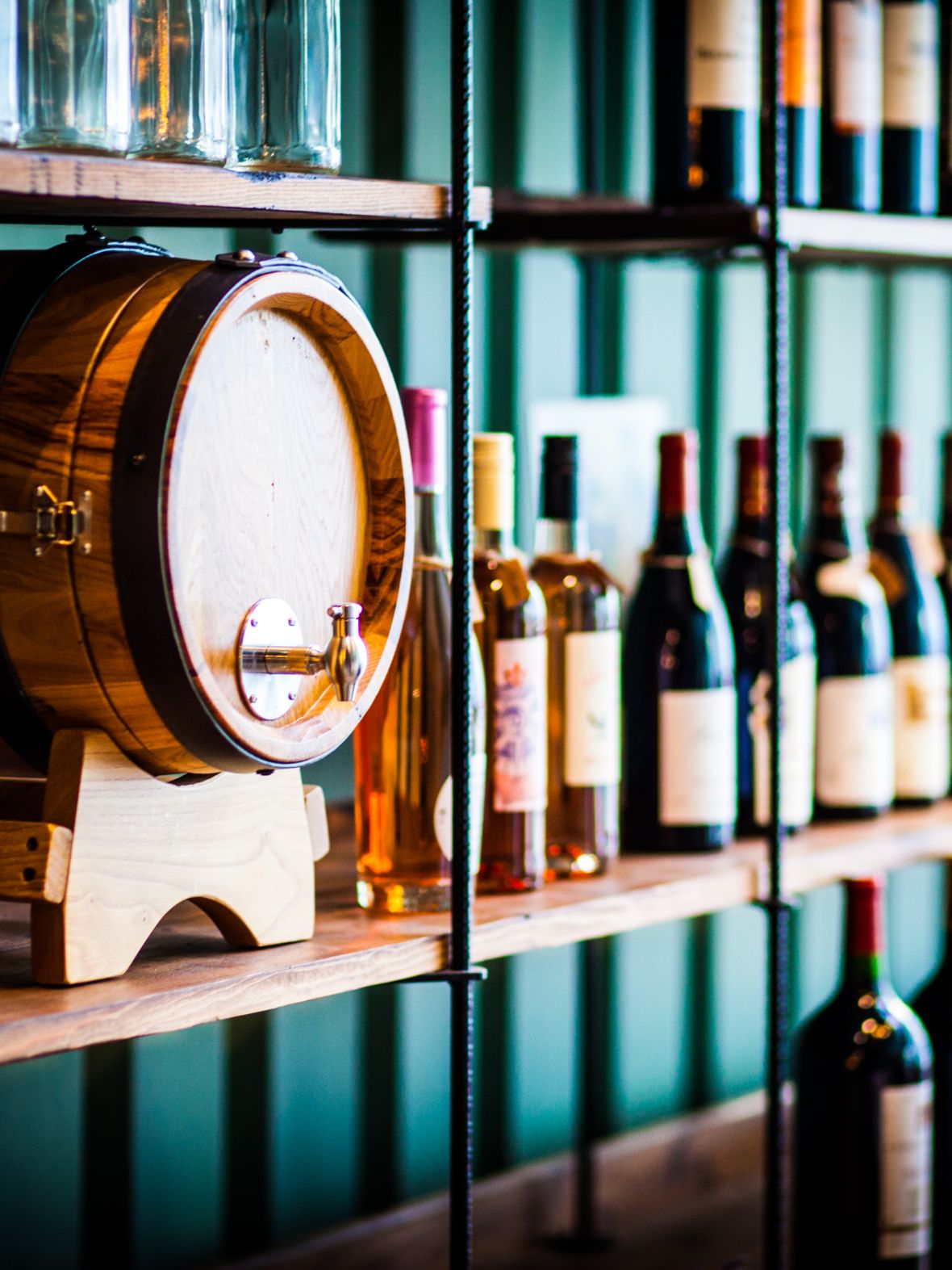 Wine barrel and bottles of wine on shelves