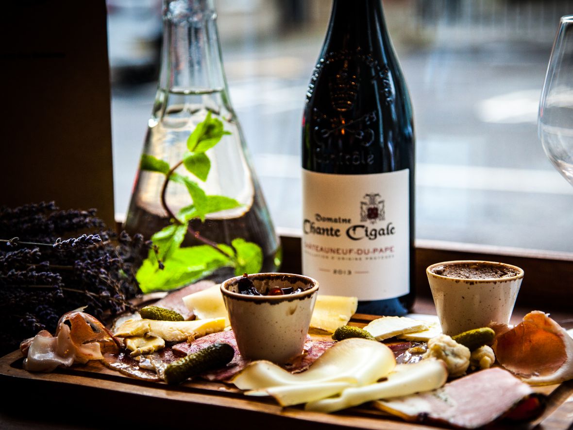 Selection of meat and cheese with a bottle of wine in background